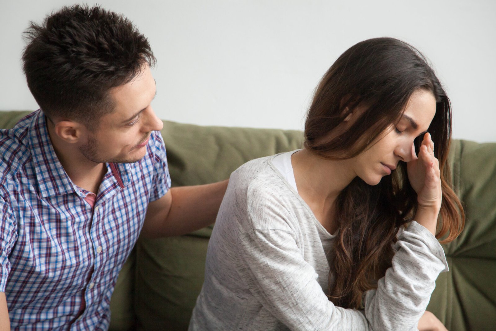 Caring husband apologizing crying wife excusing for being wrong, understanding man comforting upset woman feeling offended helping supporting sad friend, apology and forgiveness, empathy concept