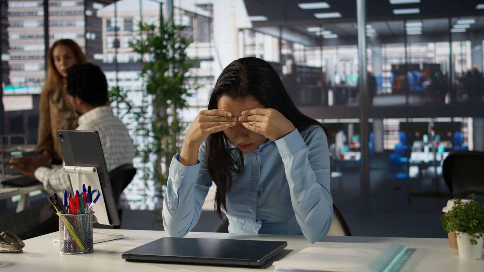 Overwhelmed indian businesswoman faces a tough day at the office, dealing with pressure and anxiety. Stressed tired employee suffers from mental exhaustion due to corporate tasks. Camera B.