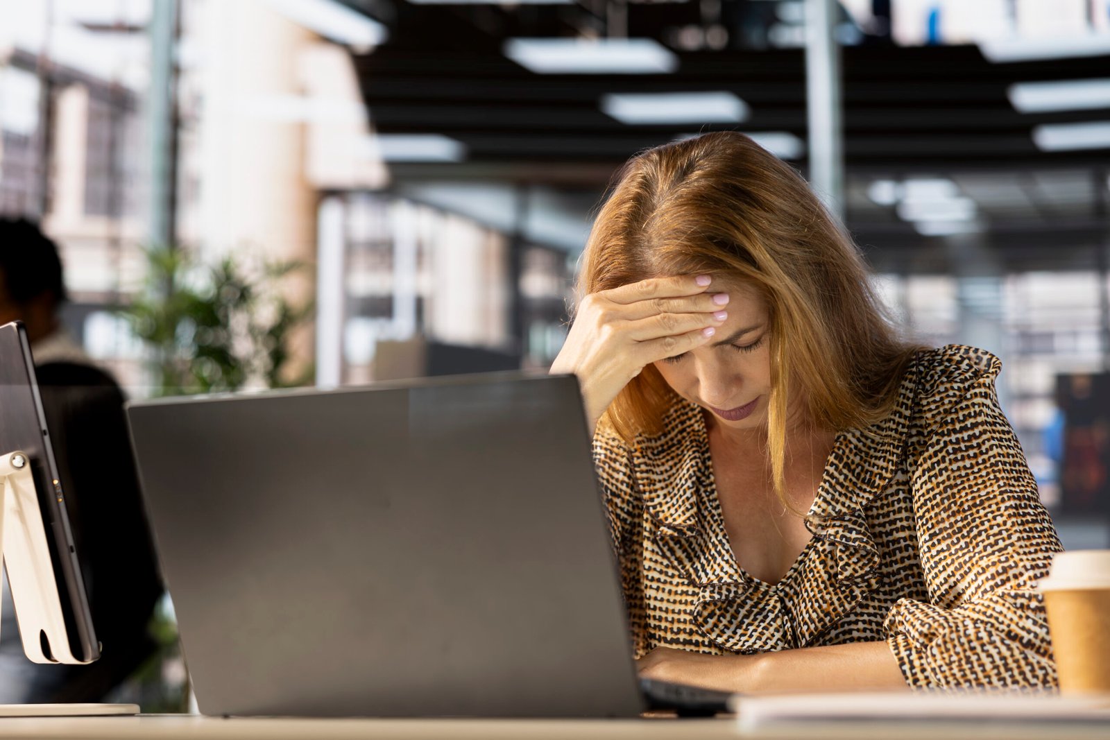 Tired businesswoman showing signs of burnout at her desk, feeling overwhelmed by the demands of her job. Worker struggles with professional challenges and emotional strain, tough day.